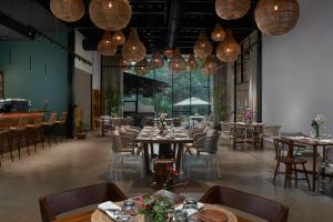 a dining room with tables and chairs and chandeliers at Avataara Resort & Spa in Anjuna