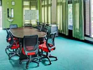 uma sala de conferências com mesa e cadeiras em OYO 92189 Wisma Inayah Syariah em Palimbão