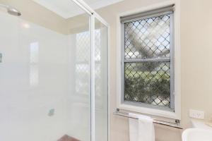 a bathroom with a shower and a window at Reflections Massy Greene - Holiday Park in Brunswick Heads