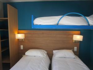 ベルク・シュル・メールにあるThe Originals Access, Hôtel les Iris, Berck-sur-Merの二段ベッド2組が備わるドミトリールームのベッド2台分です。