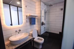 Baño blanco con lavabo y aseo en Ceria Hotel en Kuala Lumpur