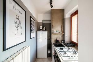a kitchen with a white refrigerator and a stove at Apartment Piazza Roma by Quokka 360 - historic flat in the centre of Como in Como