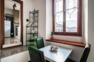 a dining room with a table and a window at Apartment Piazza Roma by Quokka 360 - historic flat in the centre of Como in Como