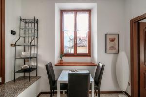 a dining room with a table and chairs and a window at Apartment Piazza Roma by Quokka 360 - historic flat in the centre of Como in Como