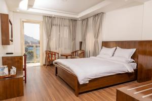 una camera da letto con un letto, un tavolo e una finestra di YULOKO GUEST HOUSE a Kathmandu