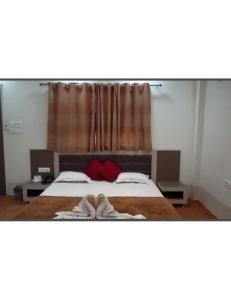 1 dormitorio con 1 cama grande con almohadas rojas en Castle Inn & Restaurant, Shivpuri, en Shivpurī