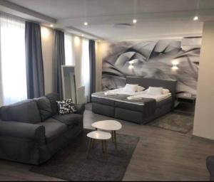 a living room with a couch and a bed at Brill Hotel B&eacute;k&eacute;scsaba in B&eacute;k&eacute;scsaba