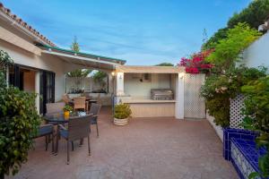a patio with a table and chairs and a kitchen at Family Villa Mijas-Costa close to the beach in Fuengirola