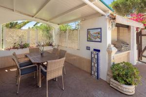 eine Terrasse mit einem Tisch, Stühlen und einem Grill in der Unterkunft Family Villa Mijas-Costa close to the beach in Fuengirola