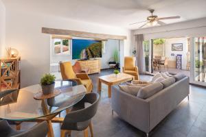ein Wohnzimmer mit einem Sofa und einem Tisch in der Unterkunft Family Villa Mijas-Costa close to the beach in Fuengirola