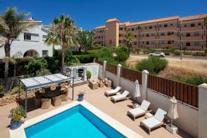 a swimming pool with lounge chairs and a building at Family Villa Mijas-Costa close to the beach in Fuengirola