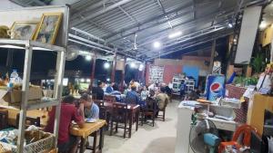 a group of people sitting at tables in a restaurant at Pakbeng Guesthouse in Pakbeng