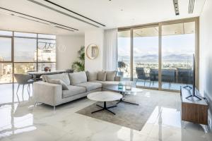 360 Nicosia - Luxury Apartment Panoramic View في نيقوسيا: غرفة معيشة مع أريكة وطاولة