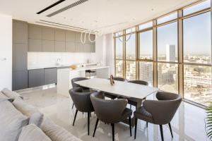 360 Nicosia - Luxury Apartment Panoramic View في نيقوسيا: مطبخ وغرفة معيشة مع طاولة وكراسي