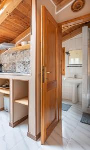 a bathroom with a wooden door and a sink at Lo chalet di Giulia - Romantic terrace in Bologna