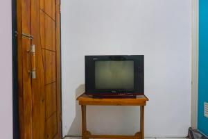 a television sitting on a table next to a door at SPOT ON 92154 Nusasari Guest House in Sukabumi