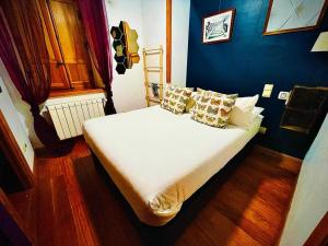 a bedroom with a white bed with a blue wall at El Torreon de Navacerrada in Navacerrada