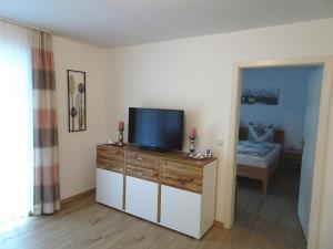 ein Wohnzimmer mit einem Flachbild-TV auf einer Kommode in der Unterkunft Appartementhaus Bayern Residenz in Bad Füssing