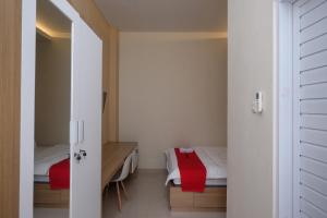 a small room with a bedroom with a bed and a door at RedDoorz Plus near UMS Solo 2 in Solo