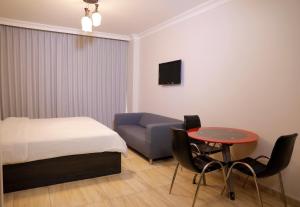 1 dormitorio con cama, mesa y sofá en Abu Alsoud Hotel, en Amán