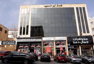 un gran edificio con coches estacionados frente a él en Abu Alsoud Hotel, en Amán