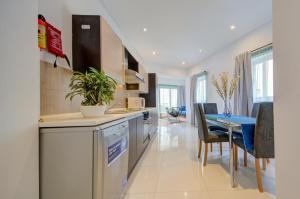 - une cuisine et une salle à manger avec une table et des chaises dans l'établissement Sapphire Residences - Apartments & Penthouse In Central Sliema By Shortletsmalta, à Sliema
