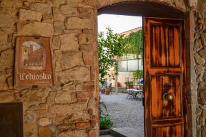a door to a building with a sign on a stone wall at Il Chiostro Appartamenti & Suites in Suvereto