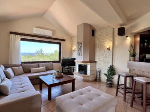 a living room with a couch and a fireplace at Villa Metapothia Gavalochori Crete in Gavalochori