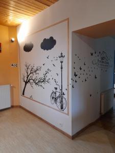 un muro con una bicicletta, un albero e nuvole di Les Hortensias GR 34 - Chambres d'Hôtes a Trévou-Tréguignec