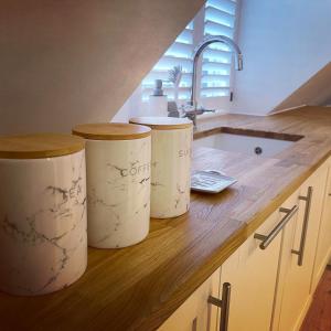 trois tonneaux de vin assis sur un comptoir dans une cuisine dans l'établissement The Loft Hatch, à Kent