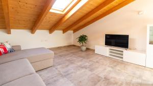 a living room with a couch and a flat screen tv at Casa Degli Artigiani-Attico con vista in Oristano