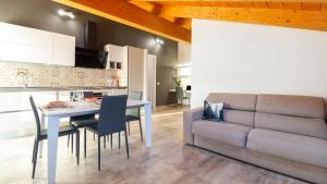 a kitchen and dining room with a table and a couch at Casa Degli Artigiani-Attico con vista in Oristano