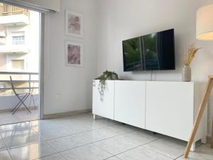 a living room with a tv on a white cabinet at Phaedrus Living Down Town Flat Stephania 302 in Limassol