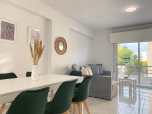 een eetkamer met een tafel en groene stoelen bij Phaedrus Living Down Town Flat Stephania 302 in Limassol