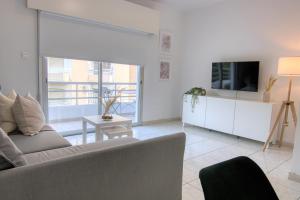 een woonkamer met een bank en een tv bij Phaedrus Living Down Town Flat Stephania 302 in Limassol