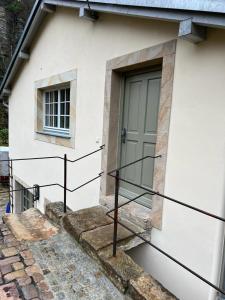 a white house with a door and a window at Ferienwohnung Parkblick im Badehaus in Schweizermühle