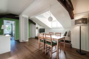 a kitchen and dining room with a table and chairs at Mansarda Verde by Quokka 360 - cosy attic apartment with lake view in Ponte Tresa