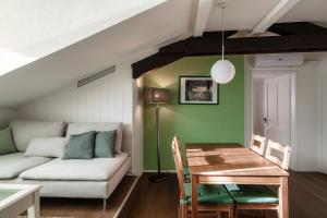 uma sala de estar com um sofá e uma mesa em Mansarda Verde by Quokka 360 - cosy attic apartment with lake view em Ponte Tresa