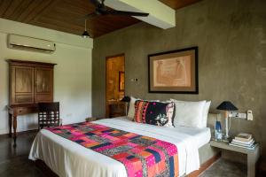 een slaapkamer met een groot bed en een kleurrijke deken bij Tranquil Waters in Negombo