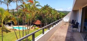 einen Balkon eines Hauses mit Pool und Palmen in der Unterkunft Club Cabana 12 - Sleeps 6 - Perfect Holiday Destination in Margate