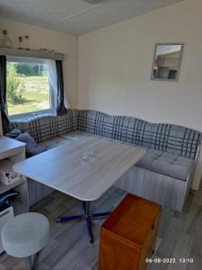 a living room with a table and a couch at mini-camping 't Bergje in Serooskerke
