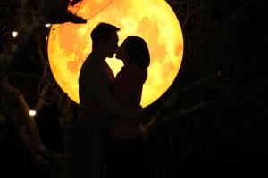 un couple s'embrassant devant une pleine lune dans l'établissement Eco House Mộc Châu, à Mộc Châu
