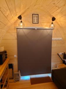 a large black screen in a room with wooden walls at Hobbit Hut in Hallstahammar