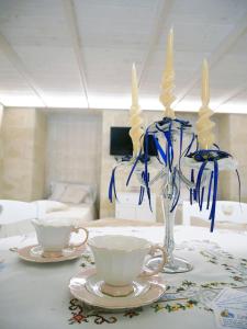 a table with two cups and a vase with candles at Casa Sant'Agata in Laterza