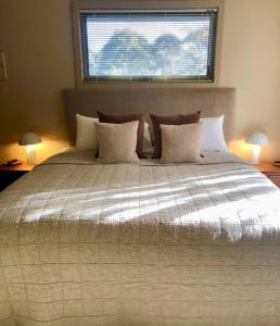 um quarto com uma cama grande e uma janela em Hepburn hideaway studio em Hepburn Springs