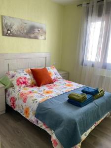 a bedroom with a bed with a flowered blanket and a window at Alojamiento rural Casa Clara la Pescaora in Trevélez