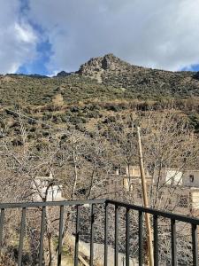 een uitzicht op een berg met bomen en een hek bij Alojamiento rural Casa Clara la Pescaora in Trevélez