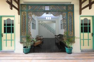 een toegang tot een gebouw met twee potplanten bij Rumah Kalpataru in Yogyakarta