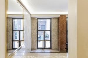 un corridoio vuoto con finestre in un edificio di Easylife - Elegante monolocale in Corso Magenta a Milano