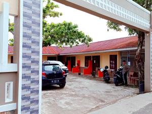 Un coche aparcado en un aparcamiento junto a un edificio. en Reddoorz at Kanaka Guest House Bengkulu, en Bengkulu